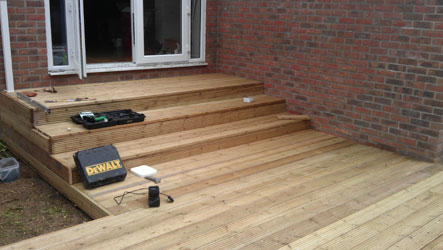 New timber decking with wide steps leading from a set of patio doors