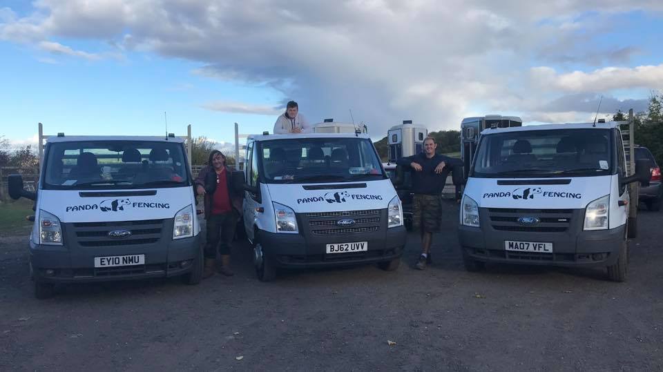Three white Panda Fencing vans with the panda logo, with the team standing beside them