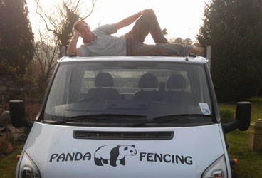 A member of the Panda Fencing team stretched out on the cab of a company van